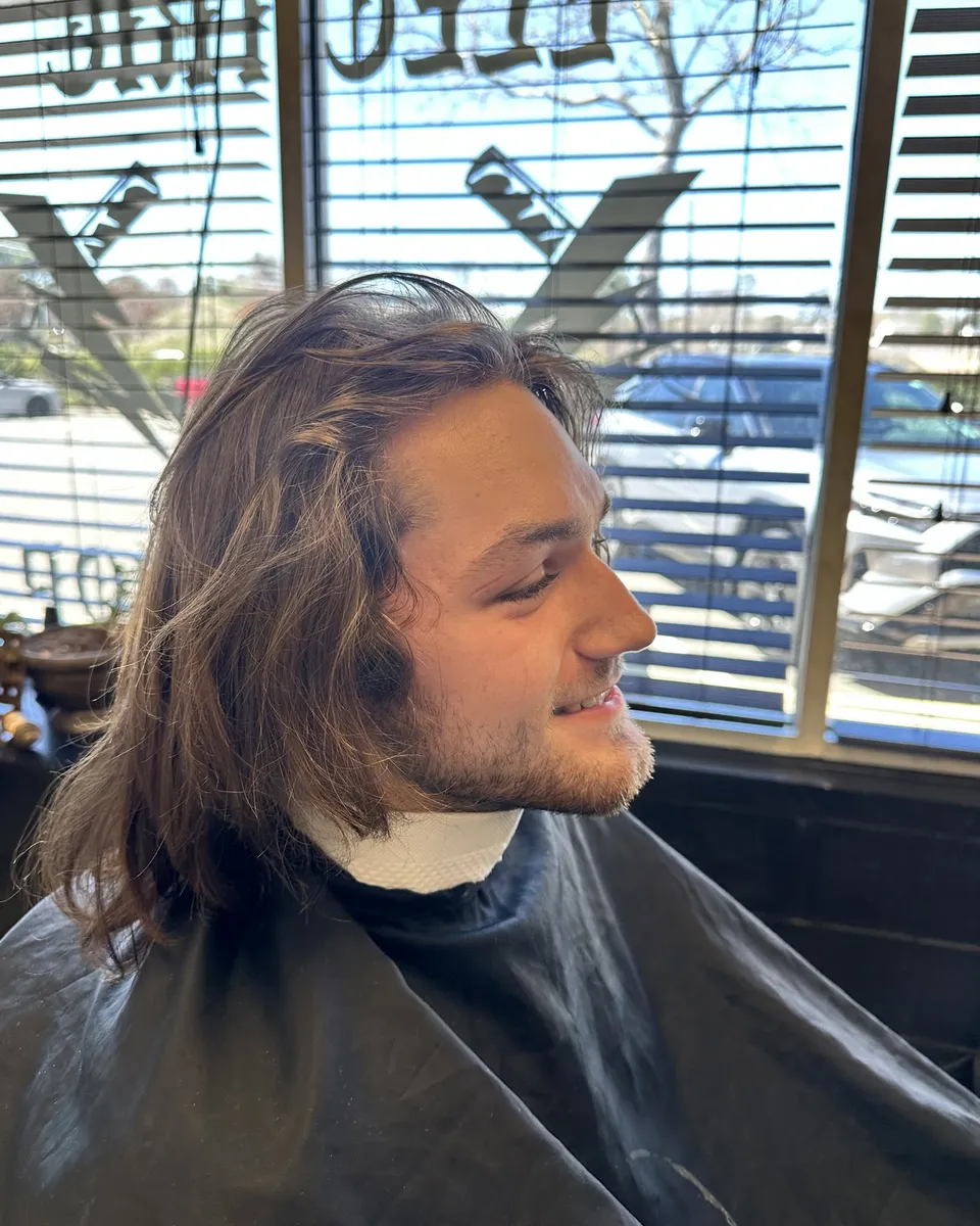 Profile of longer wavy hair in the barber chair
